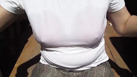 女の子が、濡れたTシャツの下から濡れた水着のブラジャーを脱ぐ