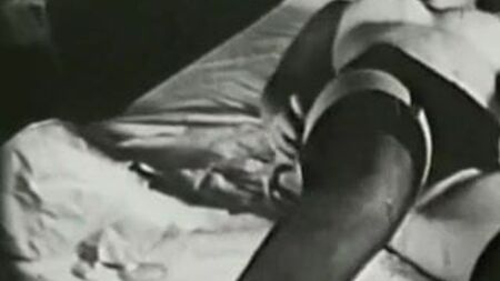 セクシーな黒いストッキングを履いたベッドの上の少女（1960年代のヴィンテージ）