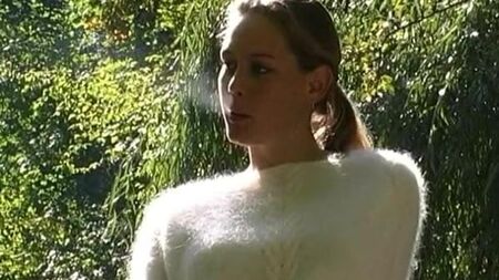 ふわふわのセーターを着た女性がタバコを吸っている