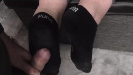 黒い汚れたプーマの靴下を履いたサックジョブ