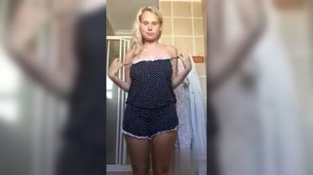 バスルームで服を脱ぐ巨乳のブロンド女性