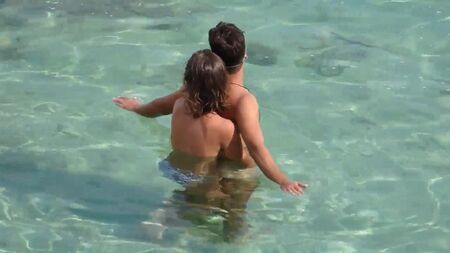 海の水中で男を運んでいる少女