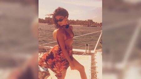 ボートに乗ったサラ・ハイランド、セクシーなビキニトップ姿